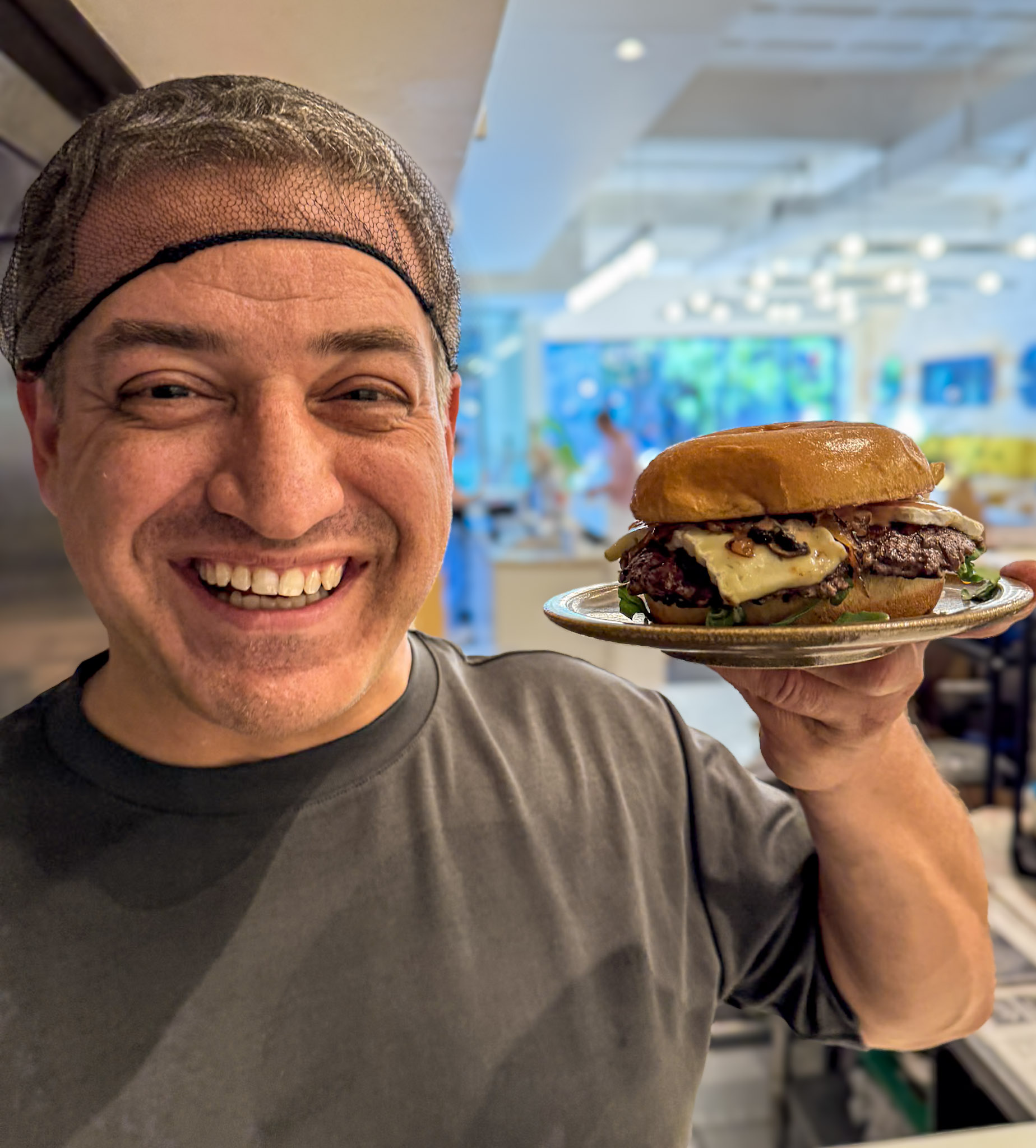 Wassim Merhi, Founder of JOYO Burger, holding a premium halal smash burger